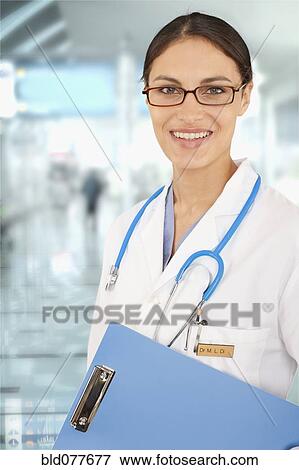 Stock Photo - Mixed race doctor holding medical chart in hospital. Fotosearch