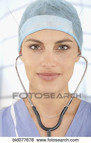 Stock Photo - Mixed race doctor wearing scrubs in hospital. Fotosearch