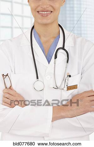 Mixed race doctor with arms crossed in hospital View Large Photo Image Stock Image - Mixed race doctor with arms crossed in hospital. Fotosearch