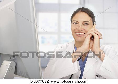 Stock Image - Mixed race doctor working in hospital. Fotosearch