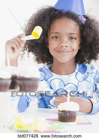 Stock Photo - Mixed race girl at birthday party. Fotosearch