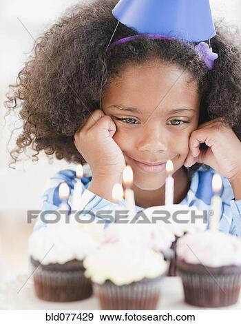 Stock Photo - Mixed race girl at birthday party. Fotosearch