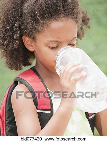 Stock Image - Mixed race girl drinking water. Fotosearch