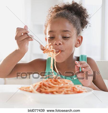 Stock Photo - Mixed race girl eating spaghetti. Fotosearch