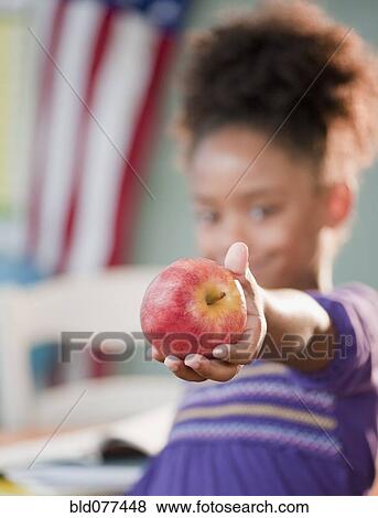 Mixed race girl holding apple View Large Photo Image Stock Photo - Mixed race girl holding apple. Fotosearch