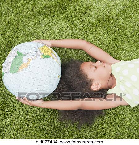 Picture - Mixed race girl holding globe. Fotosearch