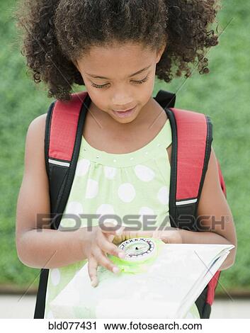 Stock Image - Mixed race girl looking at compass. Fotosearch