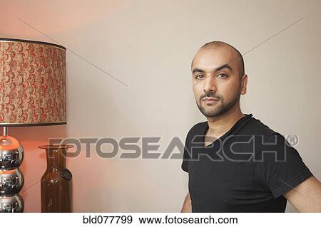 Stock Photo - Mixed race man in living room. Fotosearch