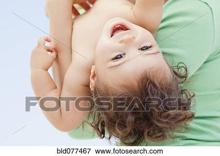Stock Photo - Mother holding Hispanic baby girl. Fotosearch