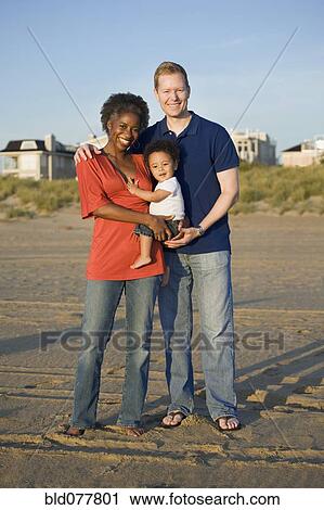 Stock Image - Multi-ethnic family enjoying beach. Fotosearch