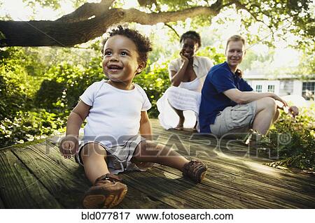 Multi-ethnic family enjoying garden View Large Photo Image Stock Photo - Multi-ethnic family enjoying garden. Fotosearch