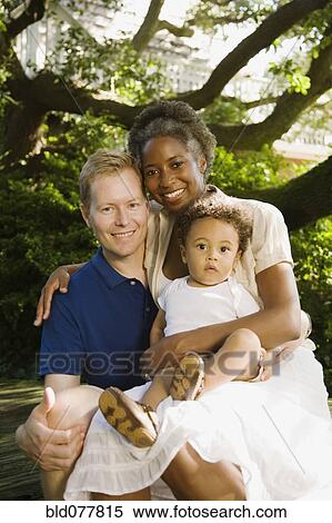 Multi-ethnic family smiling in garden View Large Photo Image Stock Photography - Multi-ethnic family smiling in garden. Fotosearch
