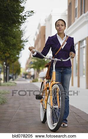 Stock Photography - African American woman riding bicycle. Fotosearch