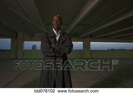 Stock Image - African businessman standing in parking garage. Fotosearch