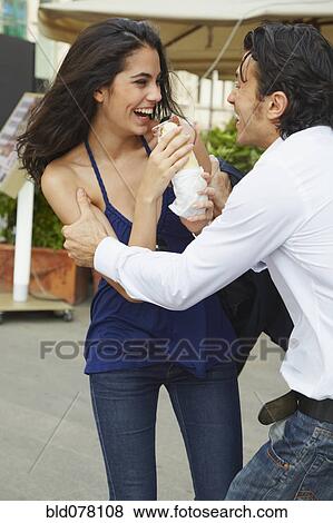 Stock Photo - Boyfriend teasing girlfriend with sandwich. Fotosearch