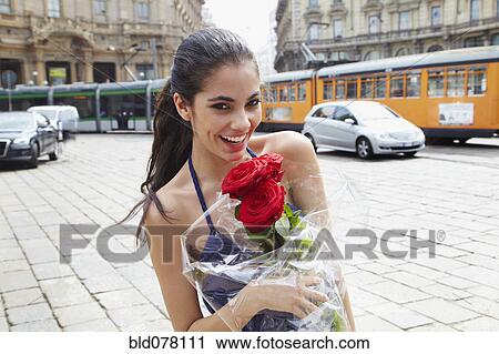 Stock Image - Brazilian woman holding red roses. Fotosearch