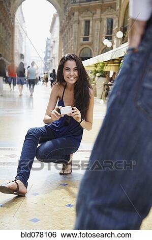 Stock Photograph - Brazilian woman photographing boyfriend. Fotosearch
