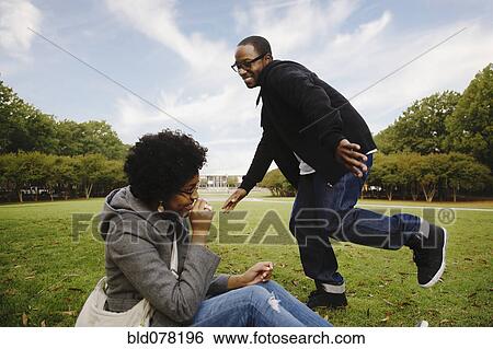 Couple playing in park View Large Photo Image Stock Photograph - Couple playing in park. Fotosearch