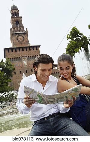 Stock Image - Couple sightseeing and looking at map. Fotosearch