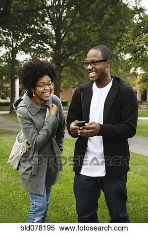 Stock Photography - Couple with cell phone in park. Fotosearch