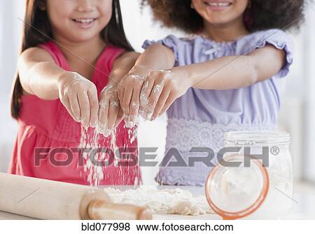 Stock Photo - Girls baking together. Fotosearch