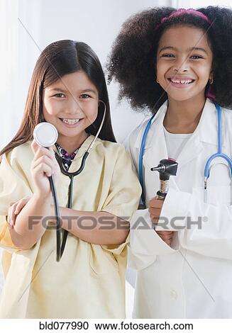 Stock Image - Girls dressed up as doctors. Fotosearch
