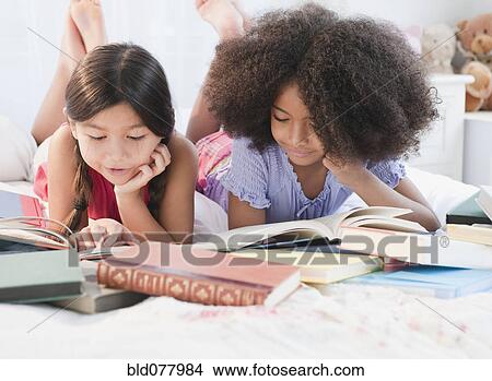Picture - Girls reading books together. Fotosearch