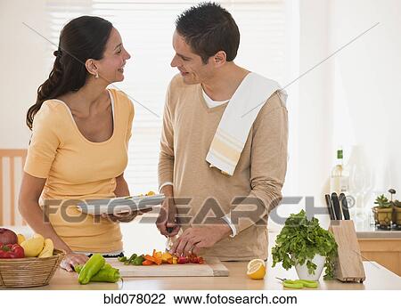 Stock Image - Hispanic couple cooking. Fotosearch