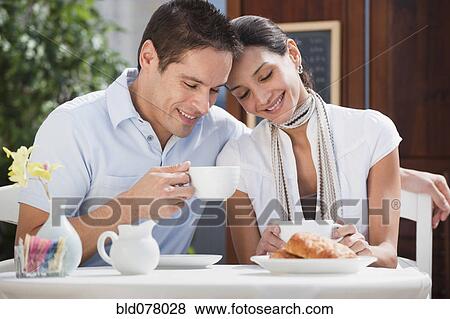 Stock Photo - Hispanic couple having breakfast in cafe. Fotosearch