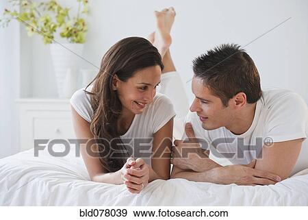 Hispanic couple laying on bed View Large Photo Image Stock Photo - Hispanic couple laying on bed. Fotosearch