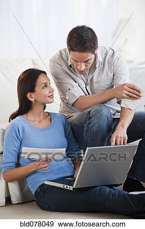 Stock Photo - Hispanic couple paying bills online. Fotosearch
