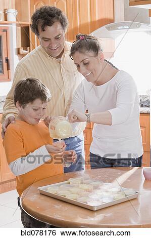 Hispanic family making cupcakes View Large Photo Image Stock Photograph - Hispanic family making cupcakes. Fotosearch