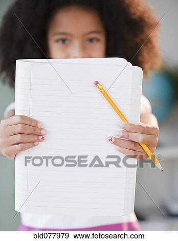 Stock Photo - Hispanic girl holding out notebook. Fotosearch
