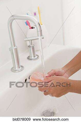 Stock Photo - Hispanic girl washing hands. Fotosearch