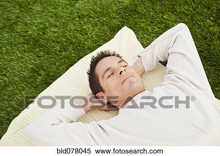Hispanic man laying on grass View Large Photo Image Stock Photography - Hispanic man laying on grass. Fotosearch