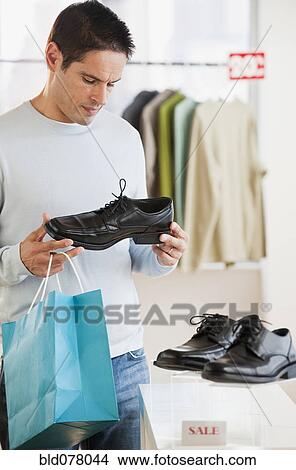 Picture - Hispanic man shoe shopping. Fotosearch