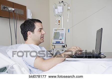 Hispanic man using laptop in hospital View Large Photo Image Stock Photo - Hispanic man using laptop in hospital. Fotosearch