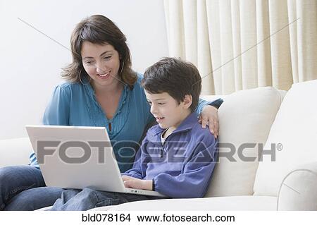 Hispanic mother and son using laptop View Large Photo Image Picture - Hispanic mother and son using laptop. Fotosearch