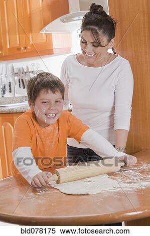 Stock Photography - Hispanic mother teaching son to bake. Fotosearch