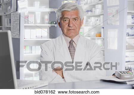 Stock Image - Hispanic pharmacist in drug store. Fotosearch