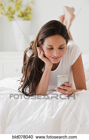 Hispanic woman looking at cell phone View Large Photo Image Stock Image - Hispanic woman looking at cell phone. Fotosearch