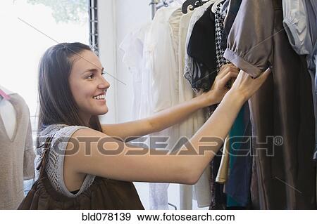 Hispanic woman shopping for clothes View Large Photo Image Stock Photo - Hispanic woman shopping for clothes. Fotosearch
