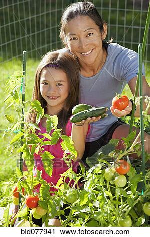 Stock Image - Japanese mother and daughter gardening. Fotosearch