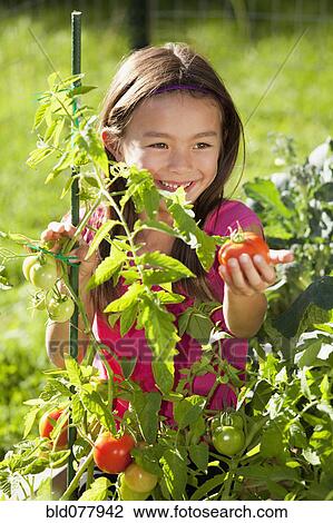 Stock Image - Mixed race girl gardening. Fotosearch