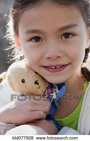 Stock Photo - Mixed race girl holding teddy bear. Fotosearch