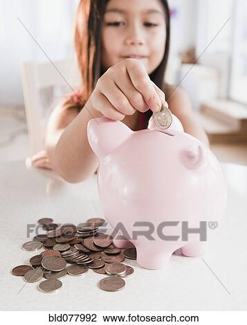 Mixed race girl putting coin in piggy bank View Large Photo Image Stock Image - Mixed race girl putting coin in piggy bank. Fotosearch