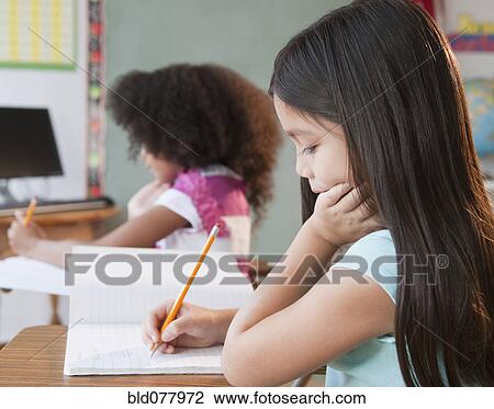 Mixed race school girl writing in notebook View Large Photo Image Stock Image - Mixed race school girl writing in notebook. Fotosearch