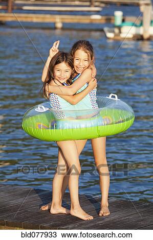 Mixed race sisters playing on pier View Large Photo Image Stock Image - Mixed race sisters playing on pier. Fotosearch