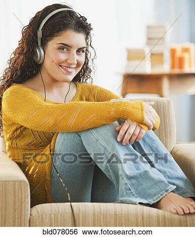Mixed race woman listening to headphones View Large Photo Image Stock Photograph - Mixed race woman listening to headphones. Fotosearch