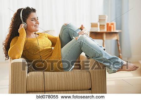 Mixed race woman listening to headphones View Large Photo Image Stock Photography - Mixed race woman listening to headphones. Fotosearch